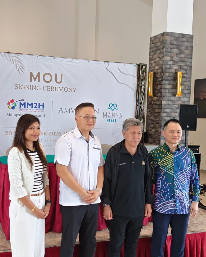 Group photograph in front of the MM2H, Amverton and MAHSA Health ceremony backdrop.